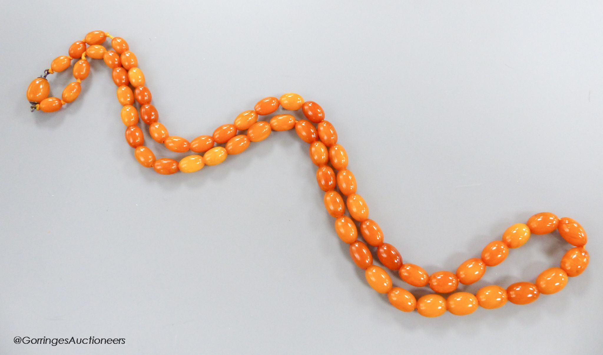 A singe strand oval amber bead necklace, 82cm, gross 45 grams.
